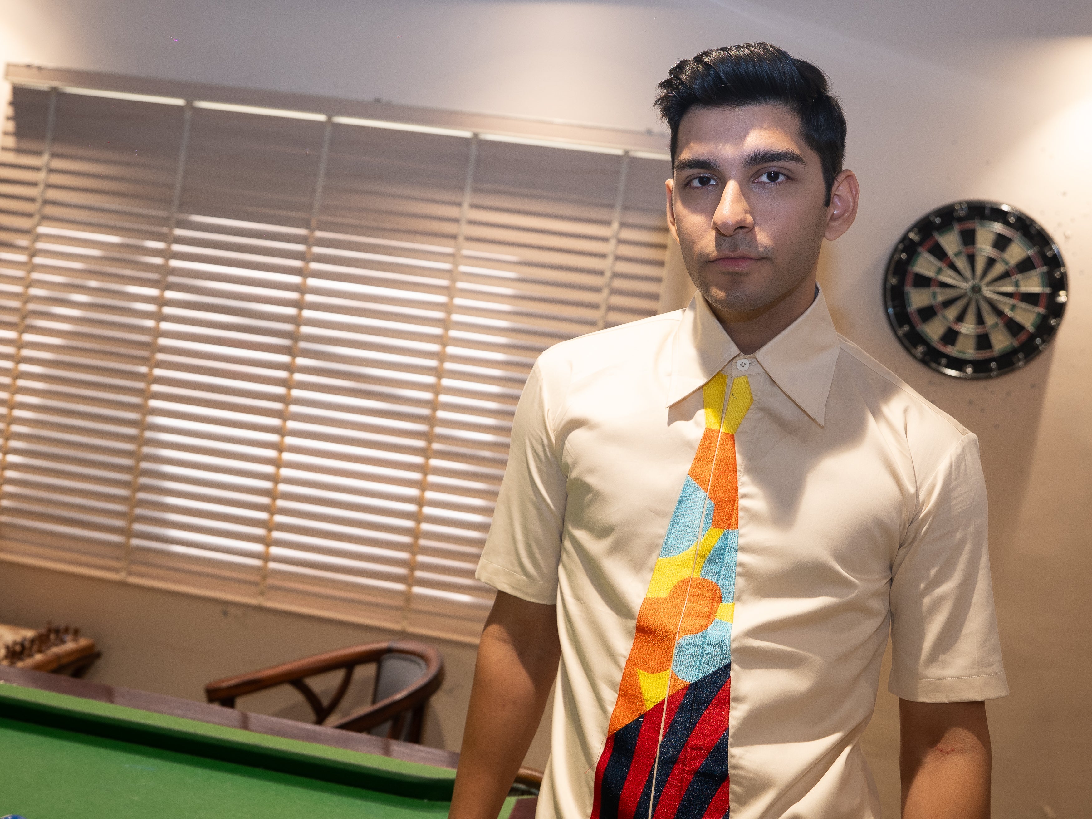 A man wearing a cream-colored short-sleeve dress shirt and a vibrant, multicolored geometric patterned tie.

Giza cotton, summers, colour, abstract, embroidery